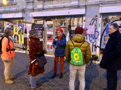 Das Foto zeigt Ortsvorsteherin Karin Guder und einige Teilnehmende des Spaziergans vor einem sanierungsbedürftigen Gebäude im Nordend